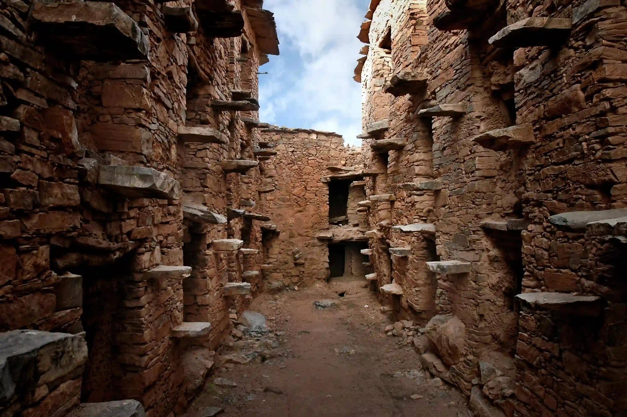 Cyclist passing the historic Old Banks of Tafraout during the Raid MTB High Atlas tour